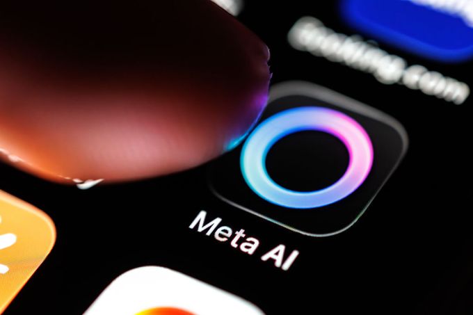 شعار تطبيق Meta AI على شاشة هاتف ذكي مع إصبع يشير إليه