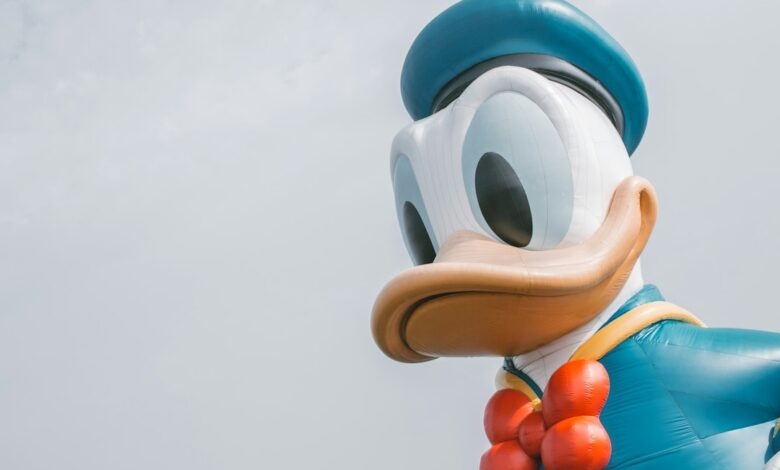 شعار Character.AI على شاشة هاتف بجوار لافتة مقر شركة Disney